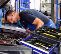 Mechanic working on a car with a toolbox open in a garage